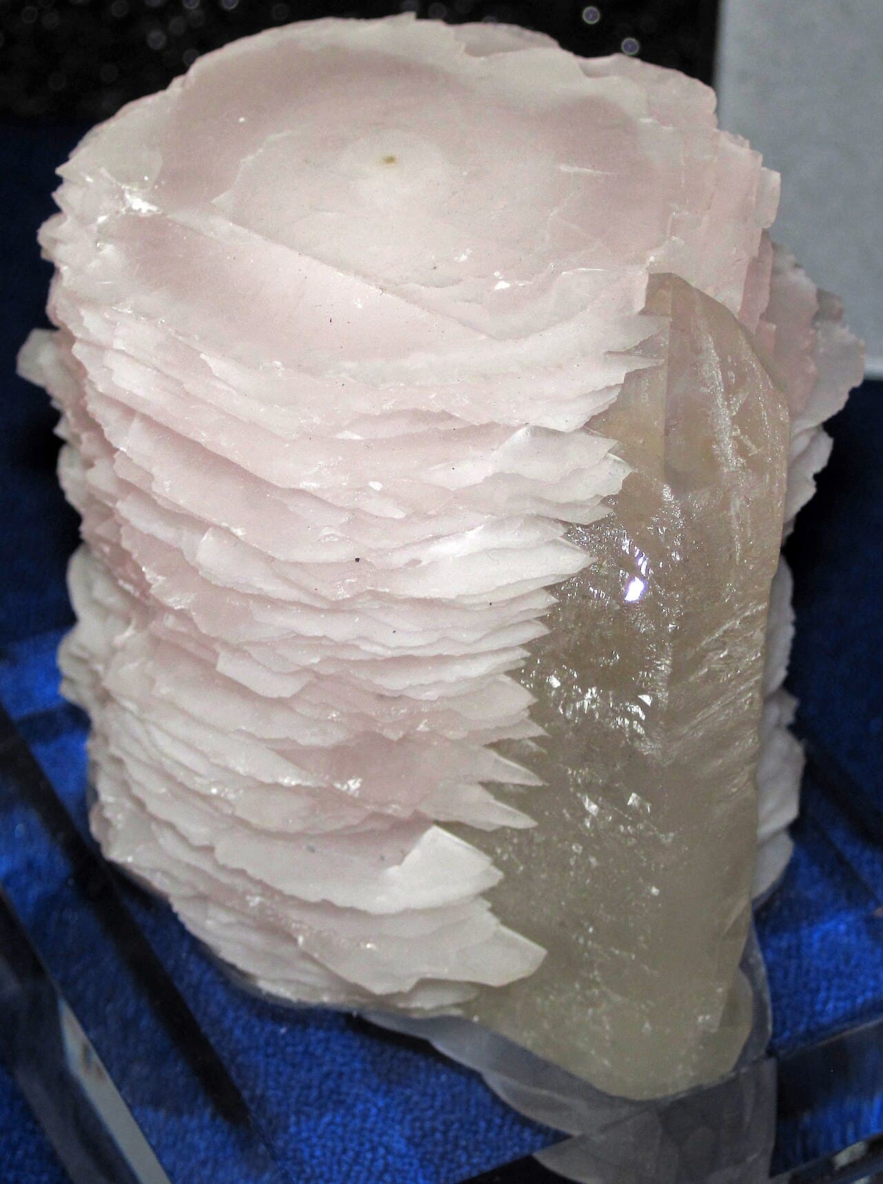 Side-by-side mineral specimen showing pale pink manganoan calcite next to gray, glassy quartz crystals