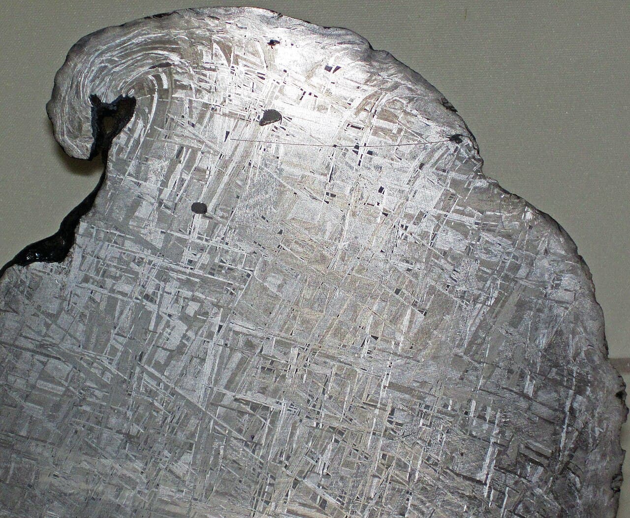 A polished and acid-etched cross-section of the Gibeon iron meteorite revealing the interlocking Widmanstätten crystal pattern that forms only in slowly cooled asteroid metal